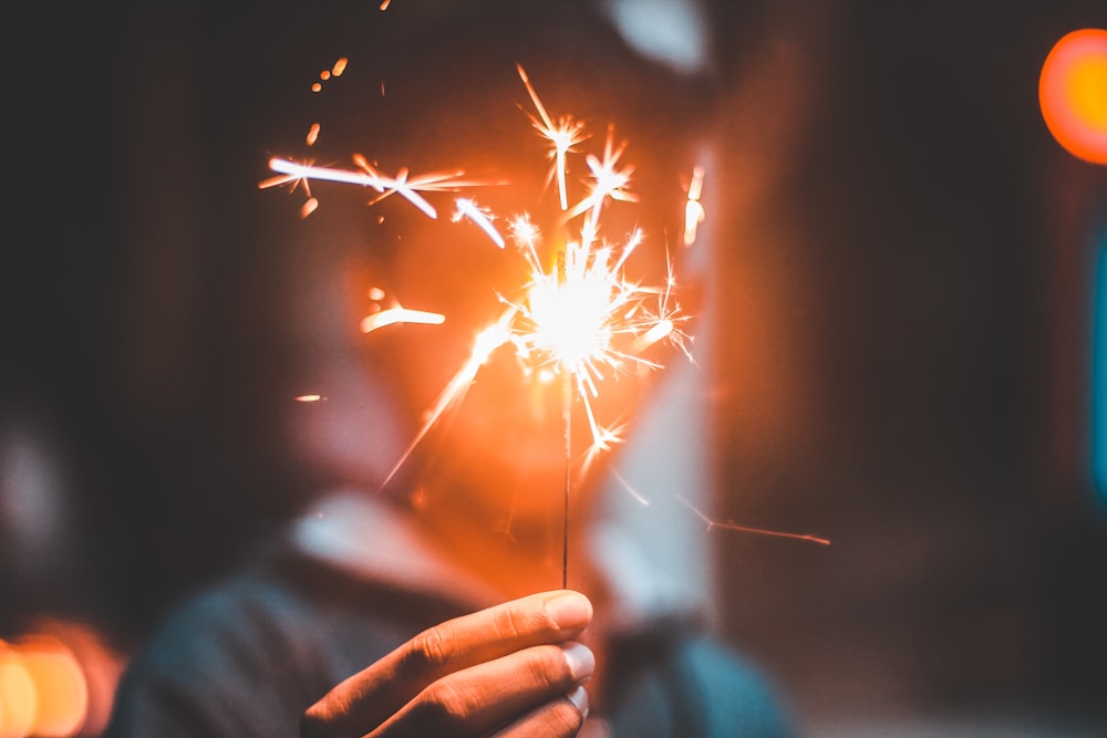 person holding lighted firecracker