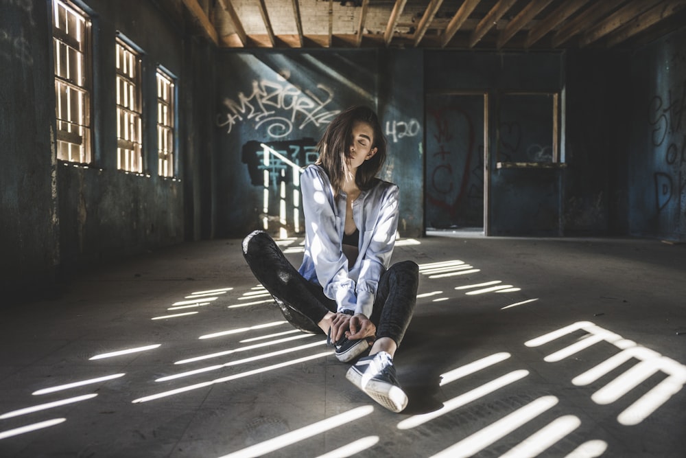 woman wearing blue jacket sitting on floor