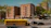 A cheerful yellow school bus driving through a leafy suburban neighborhood in the morning.