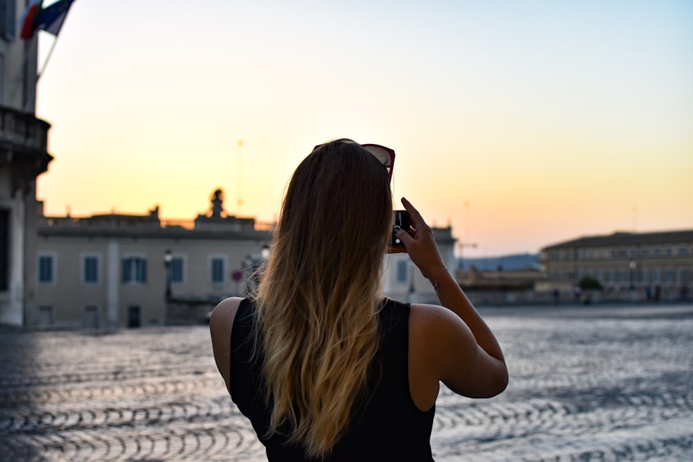 donna che tiene la macchina fotografica durante il giorno