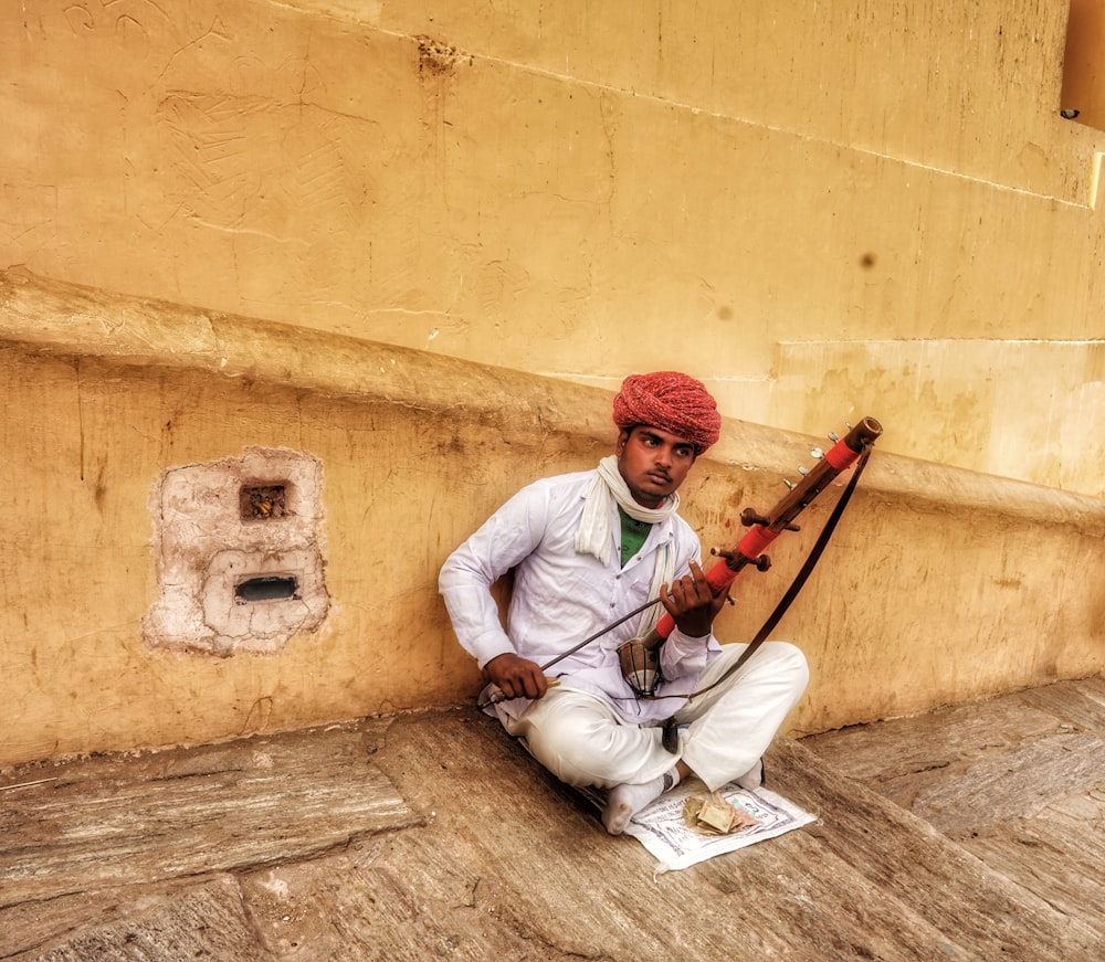 man sitting and holding string instrument