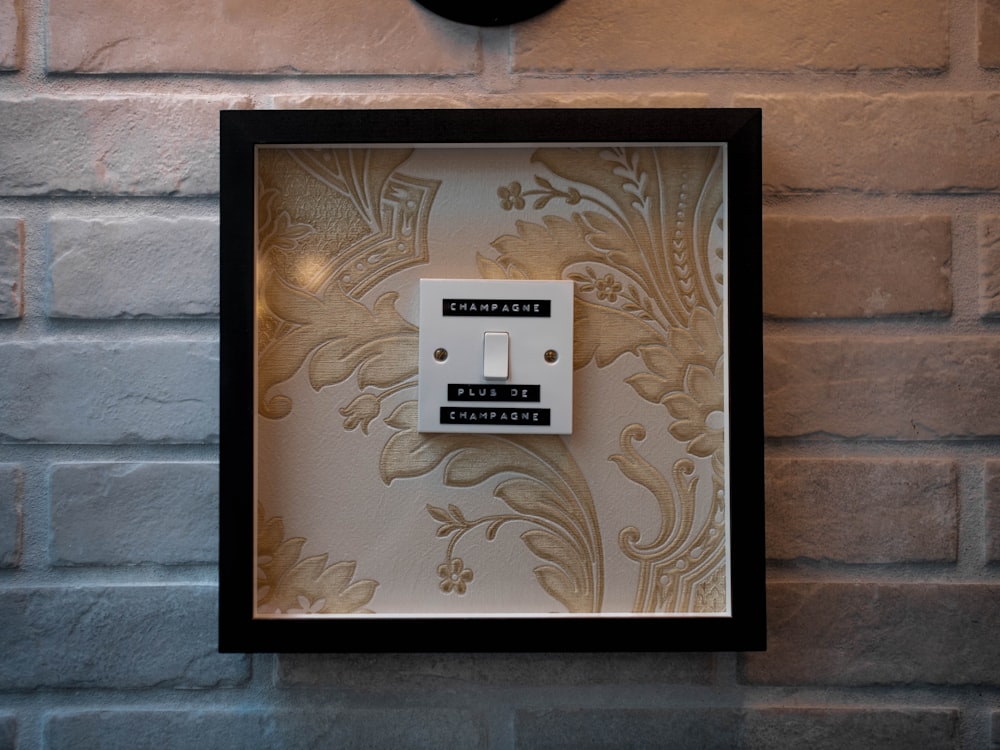 white and black switch with black wooden frame hanged on wall