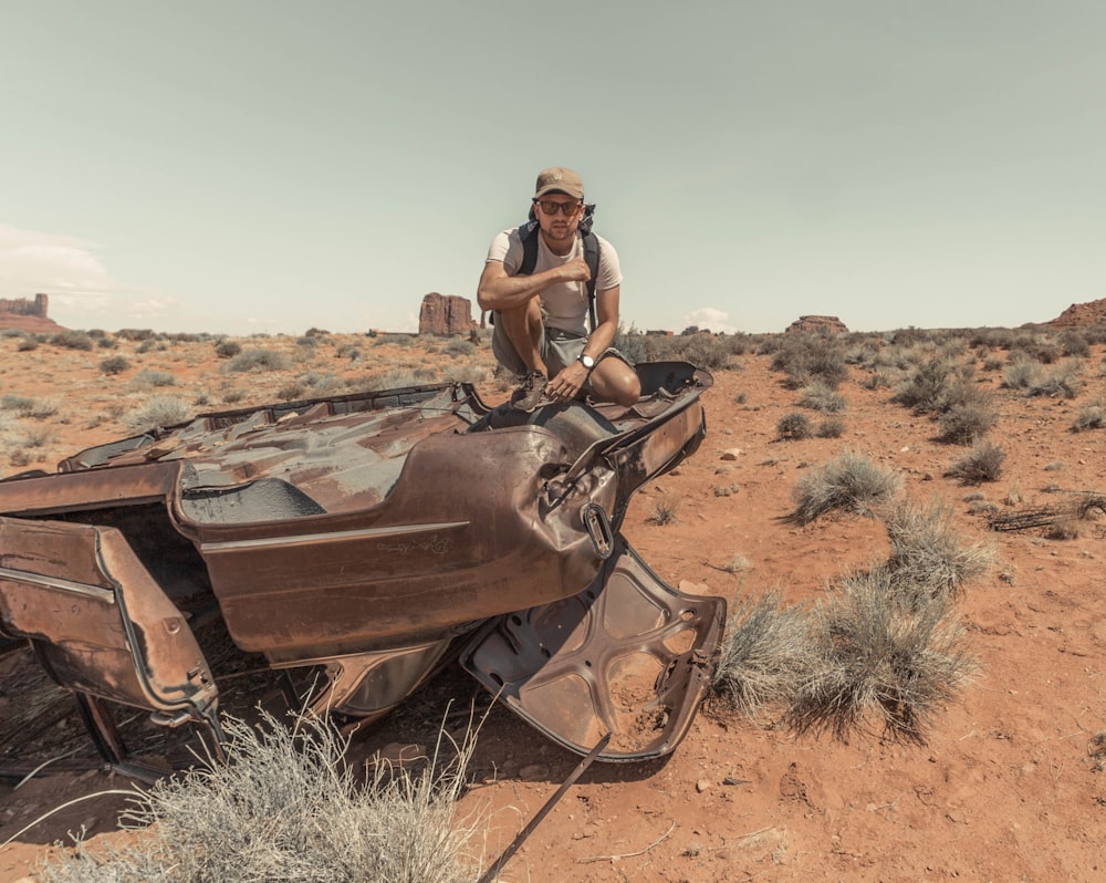 man sitting on brown wrecked vehicle