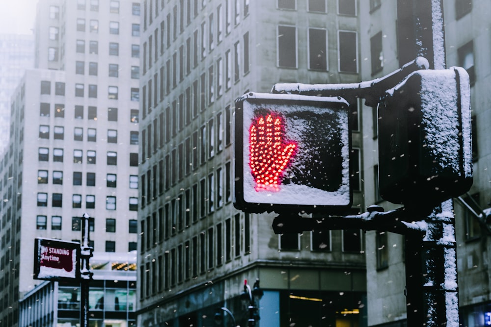Segnale stradale nero che mostra il segno rosso della mano