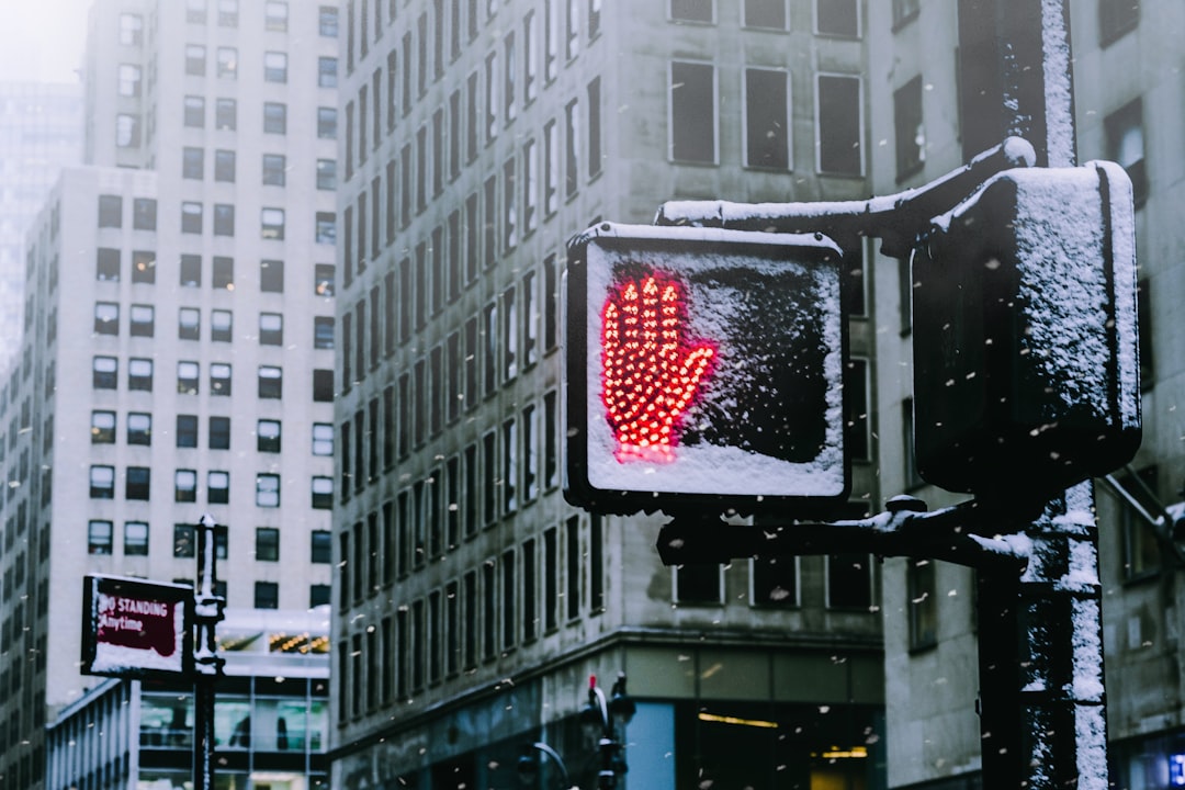 black road sign showing red hand sign