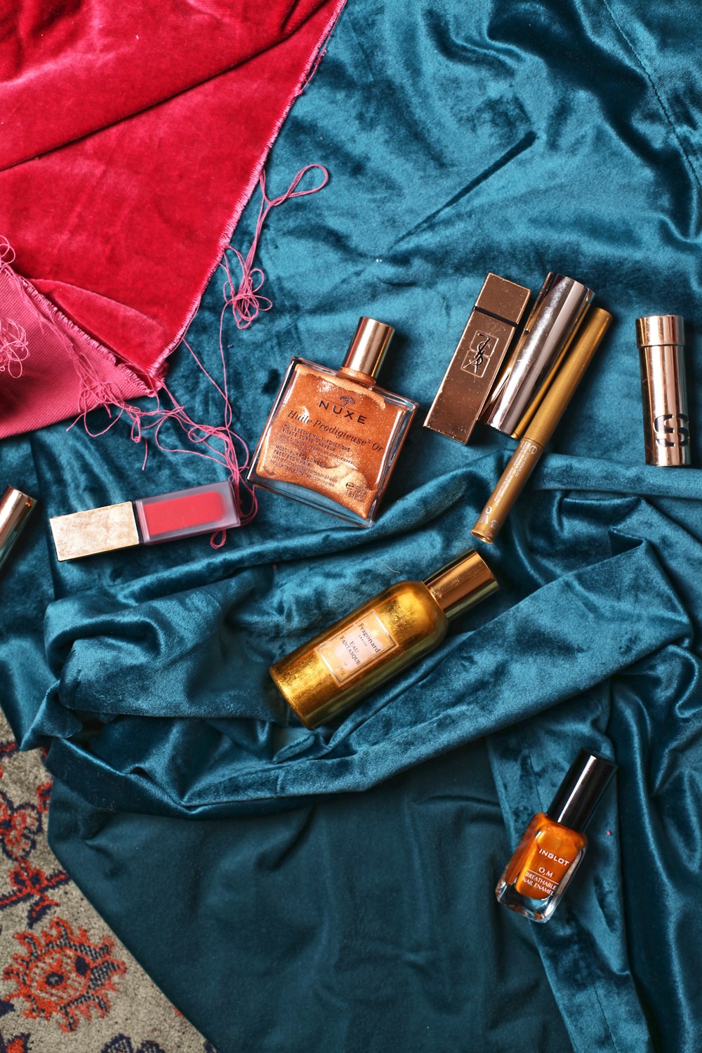 assorted cosmetics on teal textile