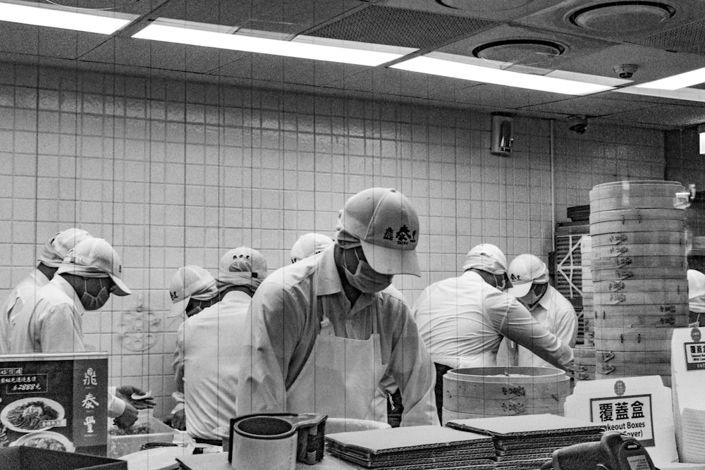 grayscale photography of workers inside room