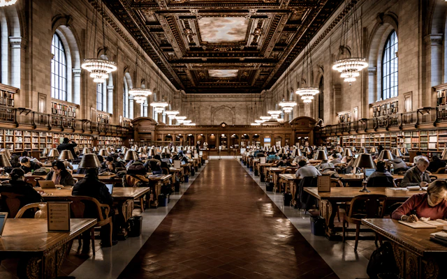 The Rose Main Reading Room of the New York Public Library, with its ornate ceiling, chandeliers and rows of wooden tables.