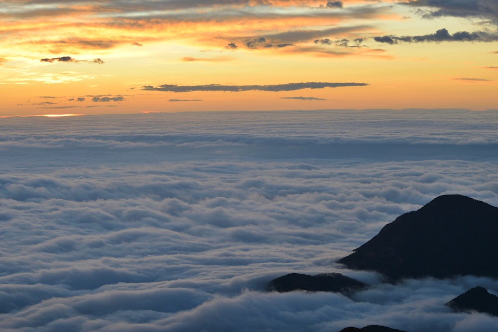 aerial photography of mountain with clouds during golden hour