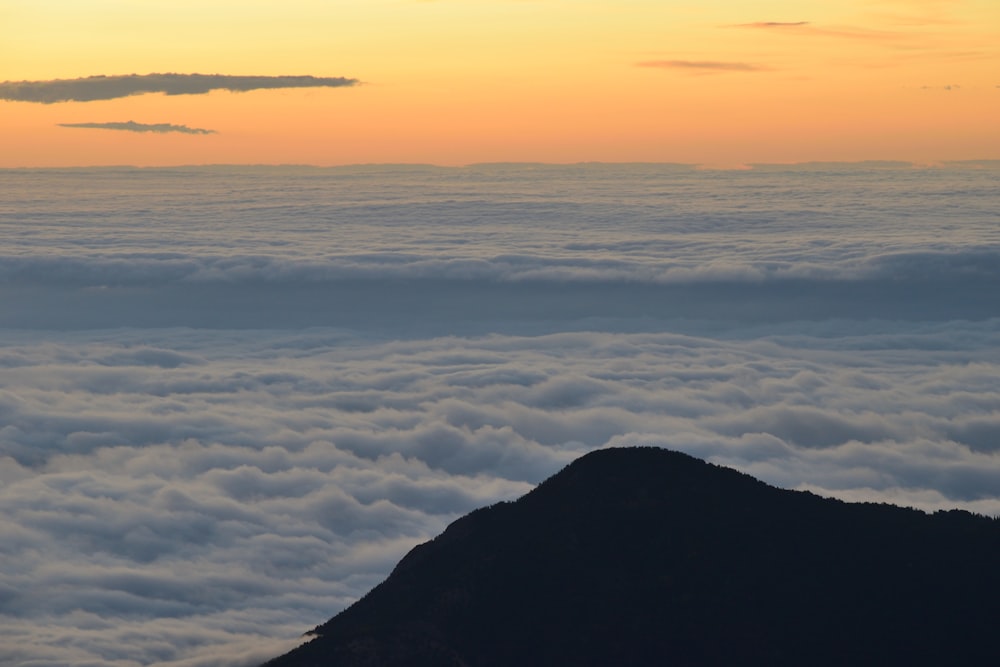 aerial photography of mountain with clouds during golden hour