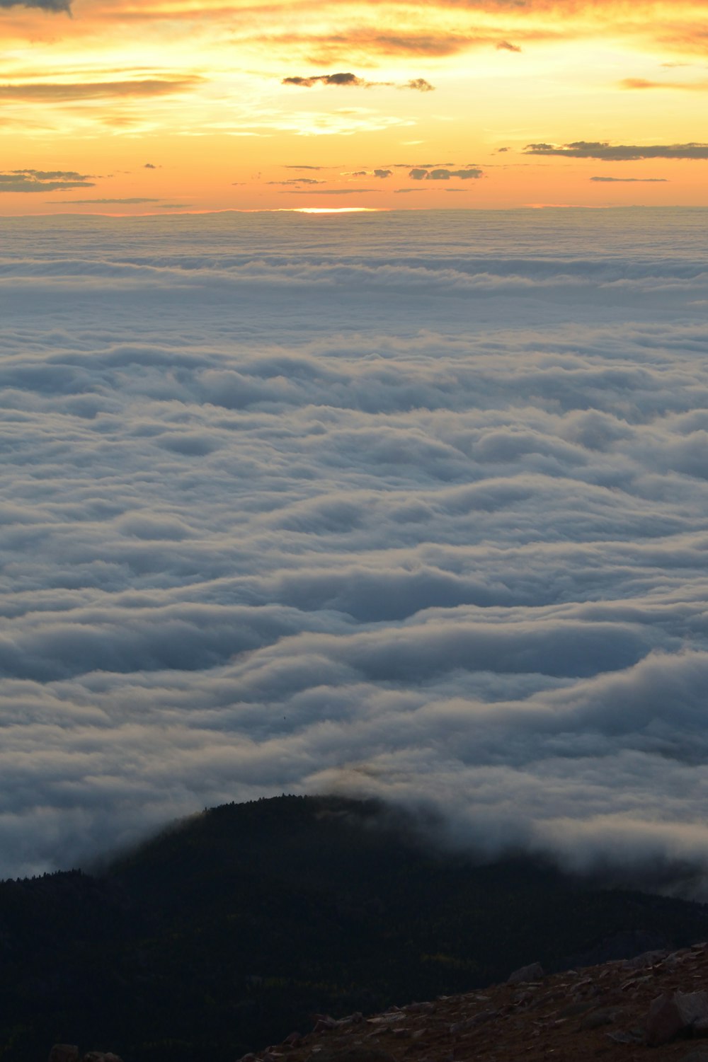 white sea of clouds under orange sky