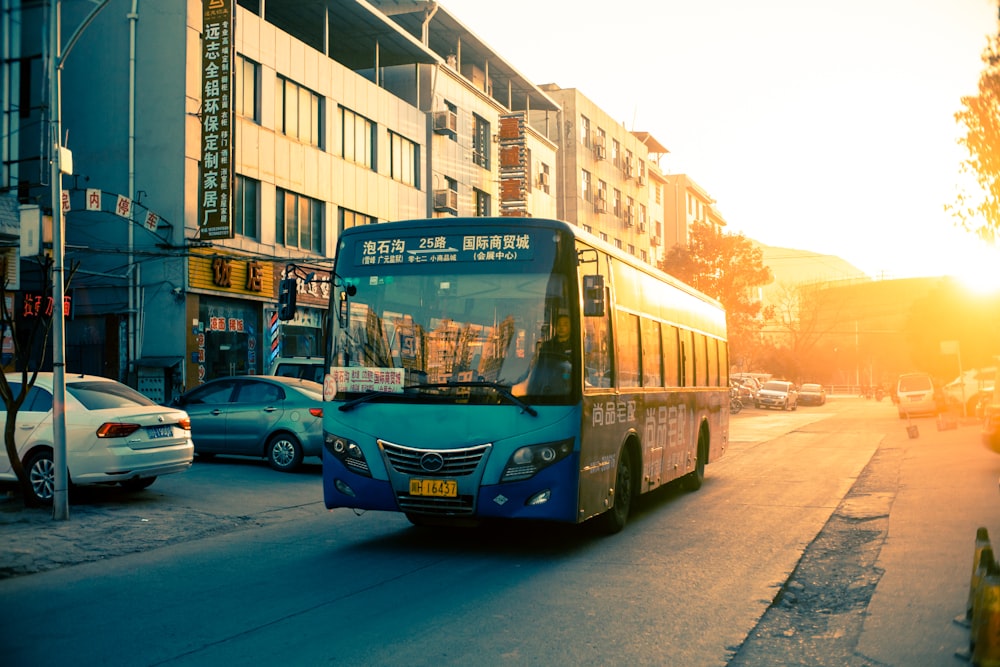blue bus on asphalt road during golden hour