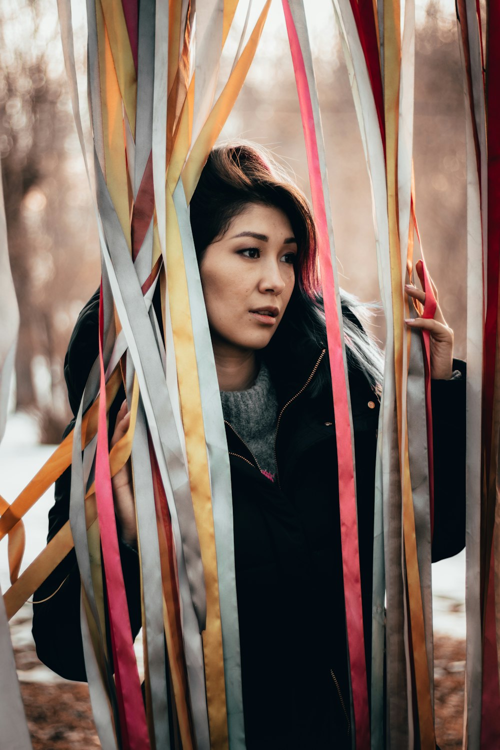 woman standing while holding ribbon curtain