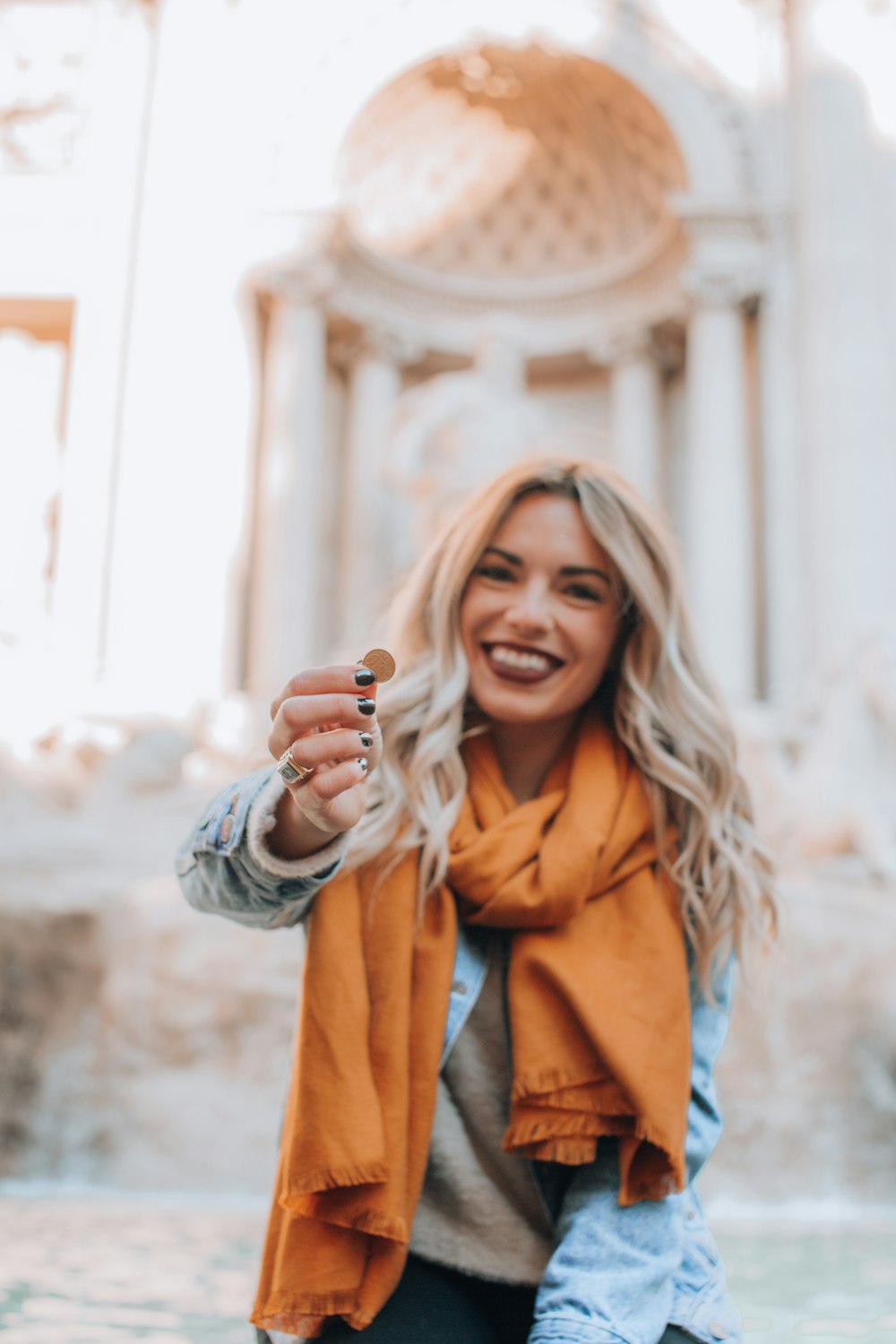 mujer sonriente sosteniendo una moneda