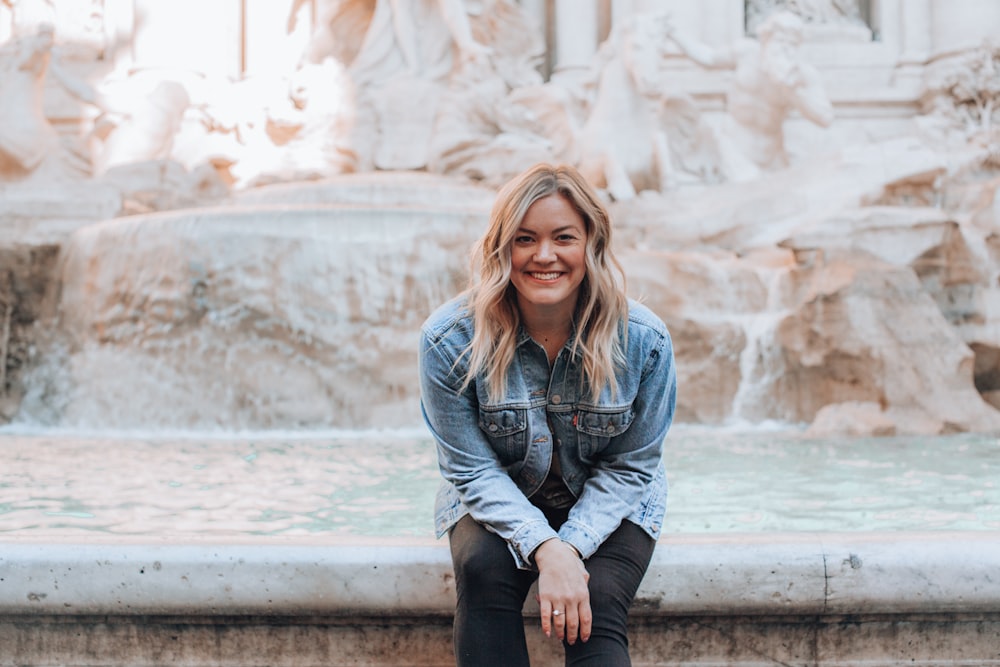 woman sitting on water fountain