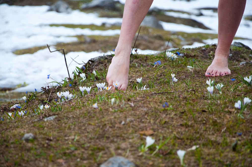 femme pieds nus sur un champ d’herbe verte