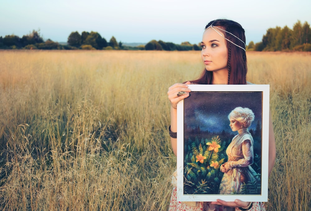 woman holding painting of woman