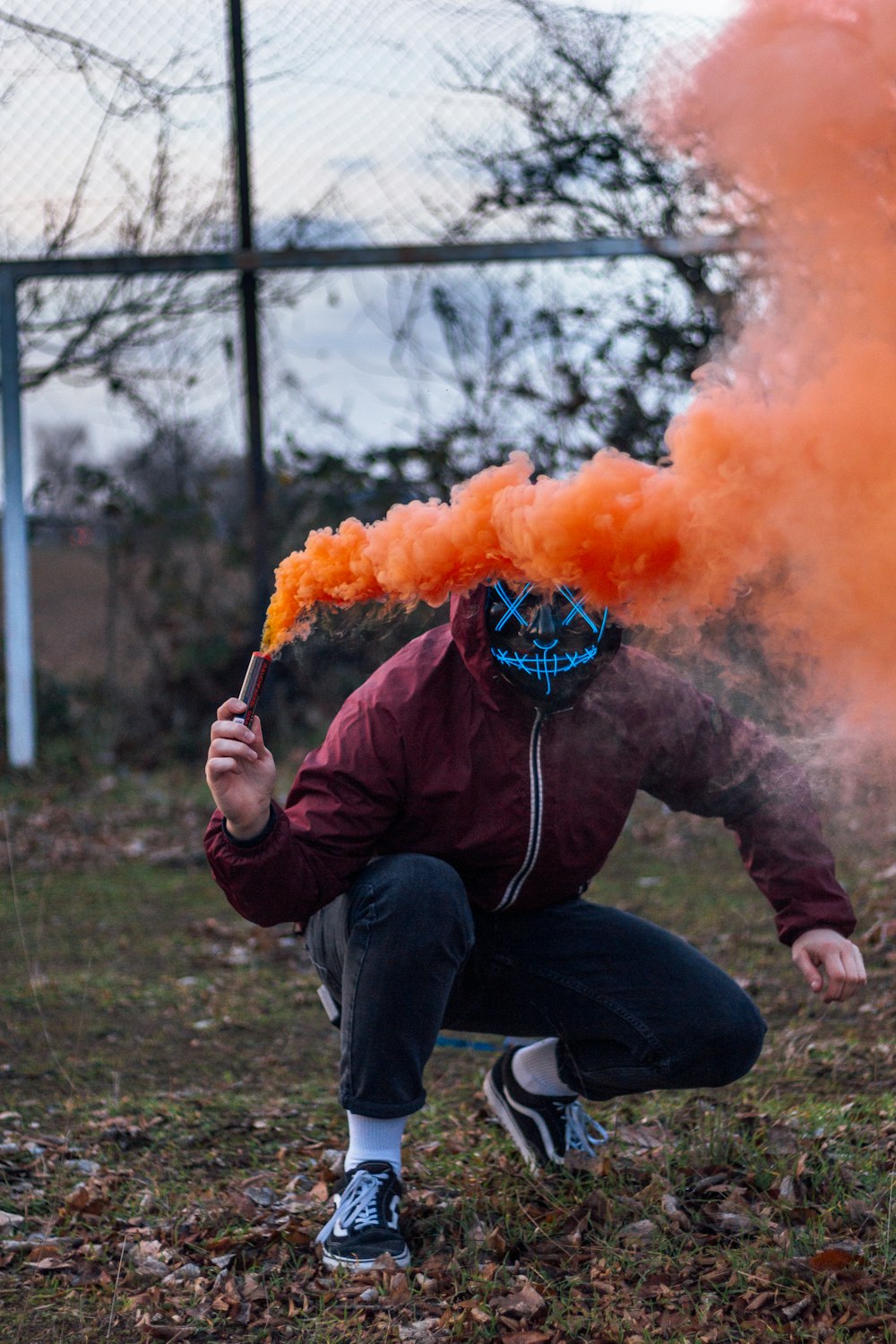 man holds orange smoke