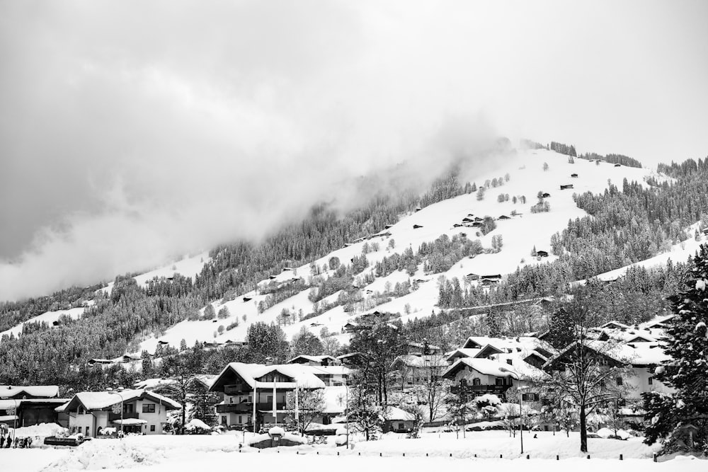 Fotografía en escala de grises de un pueblo con fondo de montaña