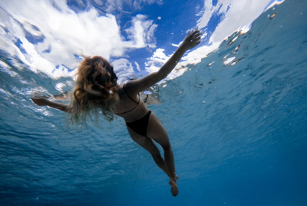 woman floating on body of water during daytime