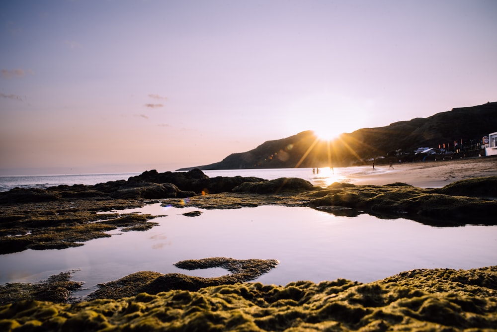 silhouette of people on body of water during sunrise