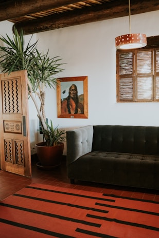 A cozy living room featuring a plush hand-tufted rug with bold geometric designs in rich reds and blues.