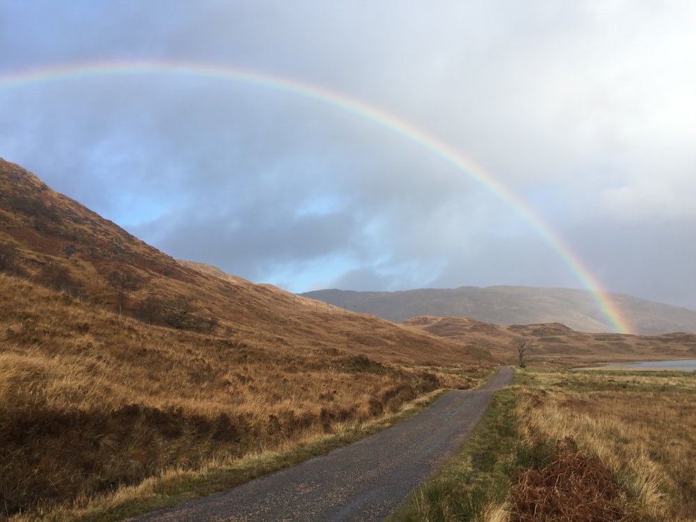 landscape photo of mountains under rainbow