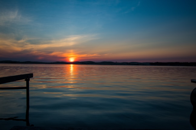 Sunset casting warm orange hues over the calm waters of Lake Texoma viewed from the rental porch.