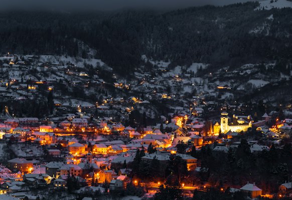 The town lit up in its valley at night — Banská Štiavnica, Slovakia