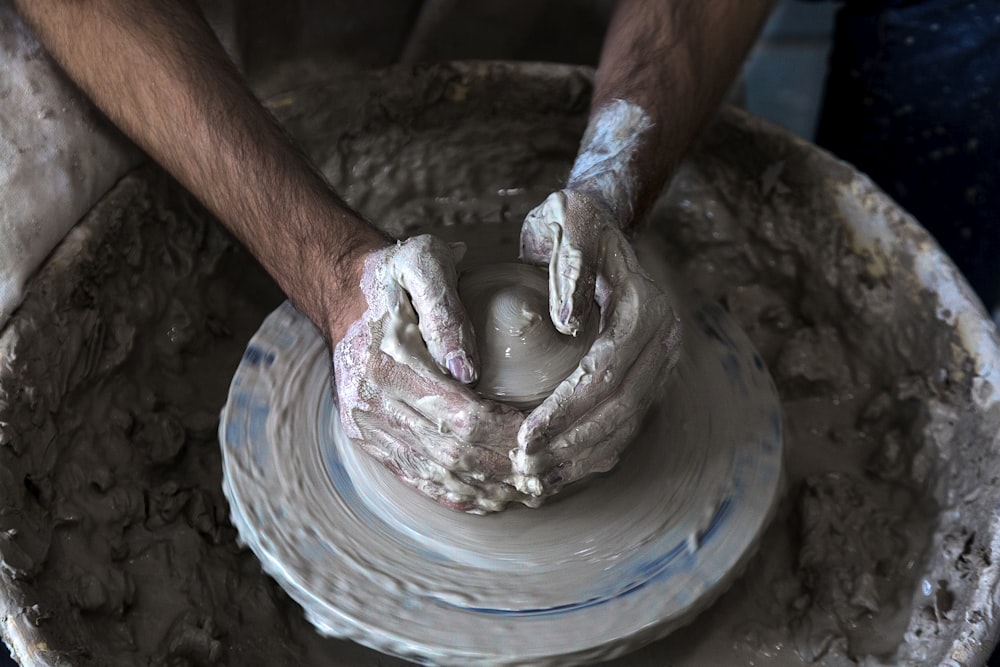 person making clay pot