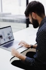 man tapping on laptop computer