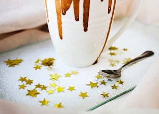 white mug with brown liquid topped with marshmallows