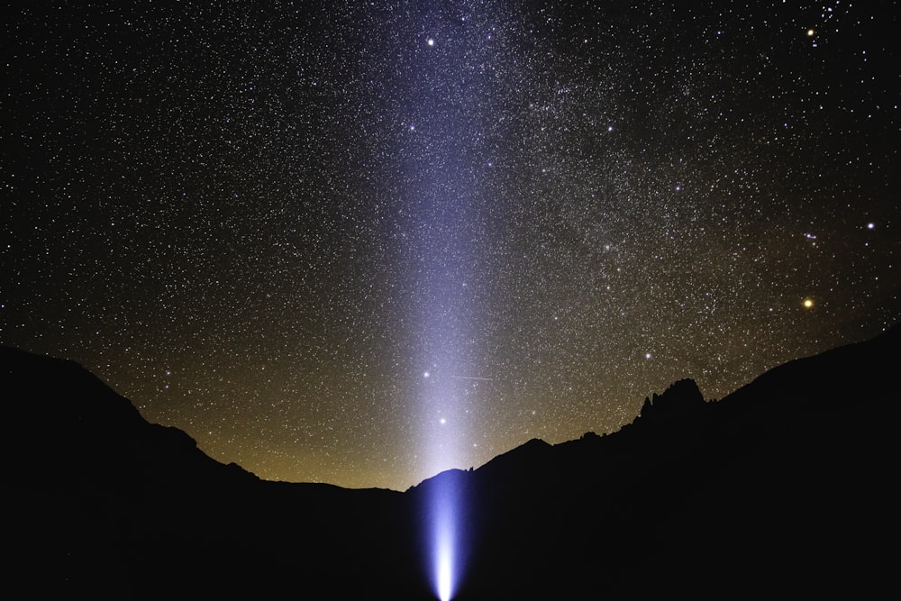 turned-on light near mountain at nighttime