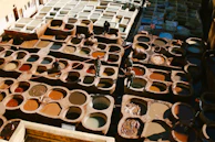 Dyeing process showing deep purple hues blending into black leather in a softly lit workshop.