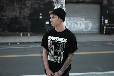 A trendy teen wearing a graphic t-shirt standing in an urban setting