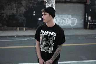 A trendy teen wearing a graphic t-shirt standing in an urban setting
