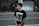 Young punk fan wearing a bold band t-shirt, smiling in a lively street of the Basque Country.