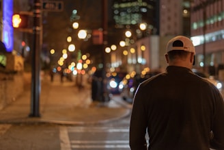 Urban street scene featuring a person wearing a charcoal exa cap with electric blue highlights.