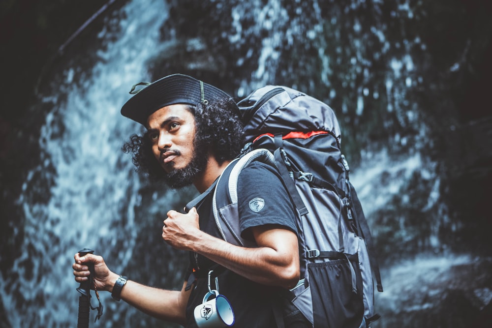 selective focus photography of man near waterfalls during daytime