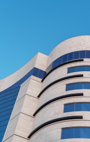 A modern building facade featuring rich stone cladding under a clear blue sky.