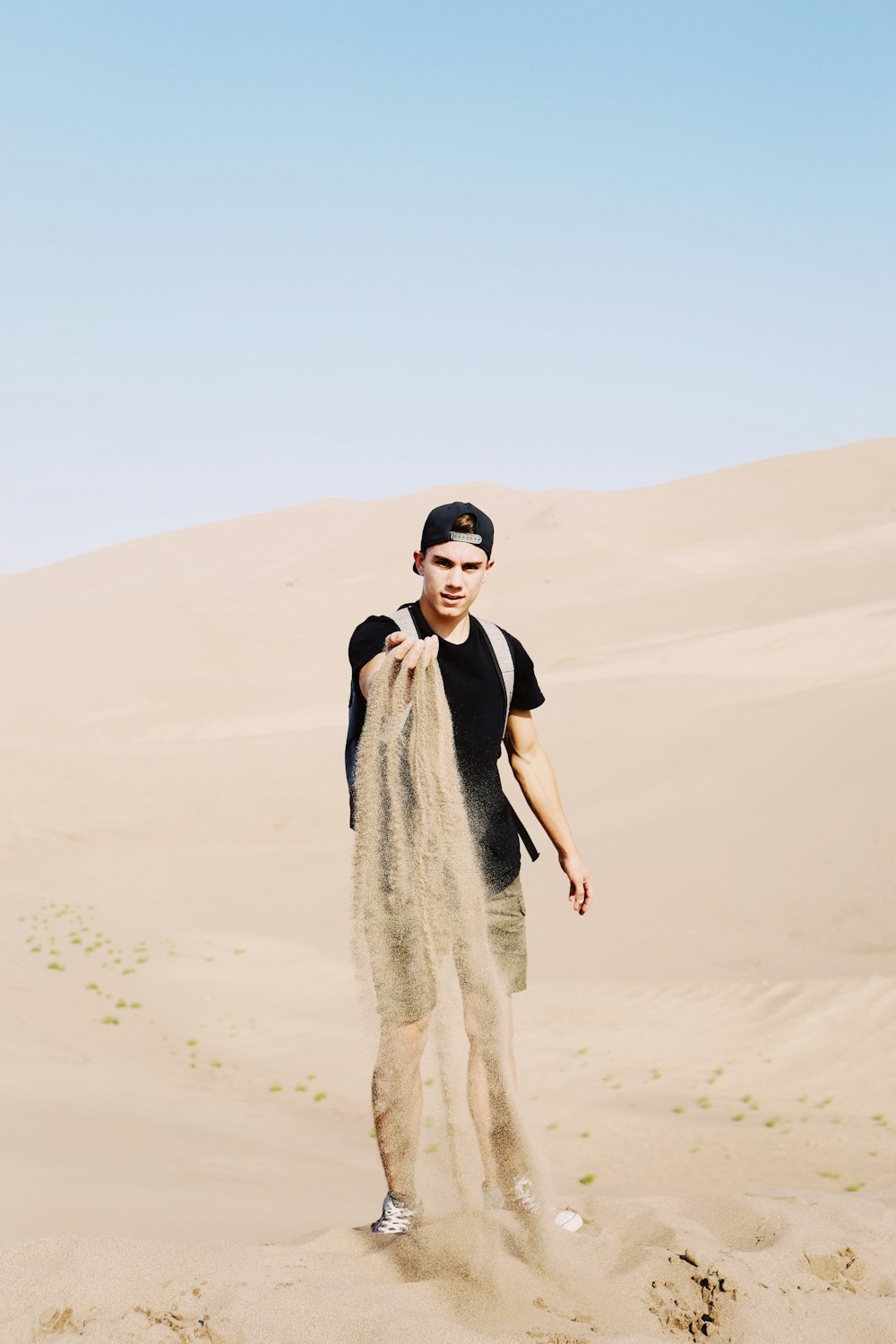 검은 셔츠를 입은 남자가 사막 랭에 서 있다