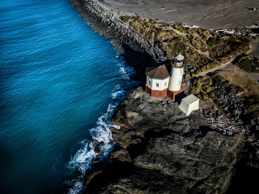 white lighthouse beside body of water