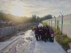 A warm photo of a family team working together on a concrete patio under a sunny sky.