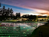 A scenic view of the Dios Padre water park at sunset with festival lights glowing softly.