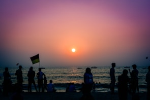 A serene beach at sunset welcoming LGBTQ+ travelers with rainbow flags fluttering.