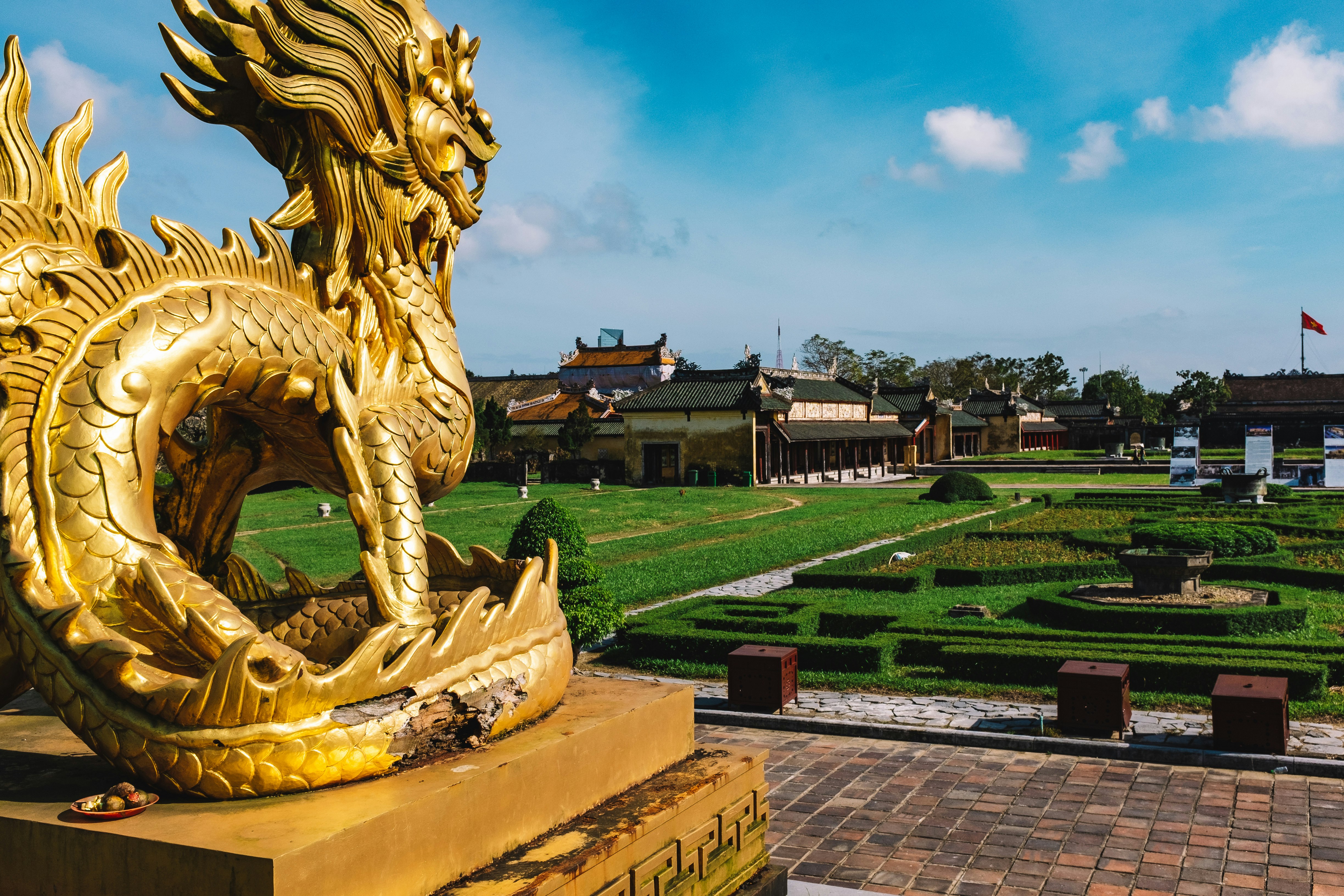 gold dragon statue near brown building during daytime