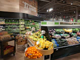 Rows of organic vegetables displayed in a clean, well-lit store aisle.
