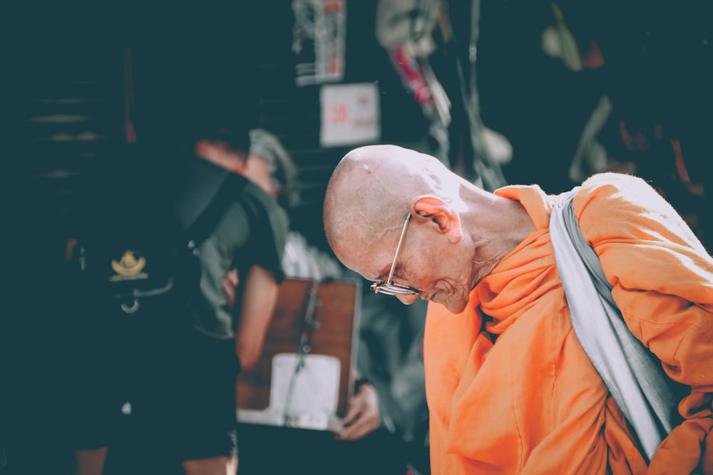 monk in orange dress looking down