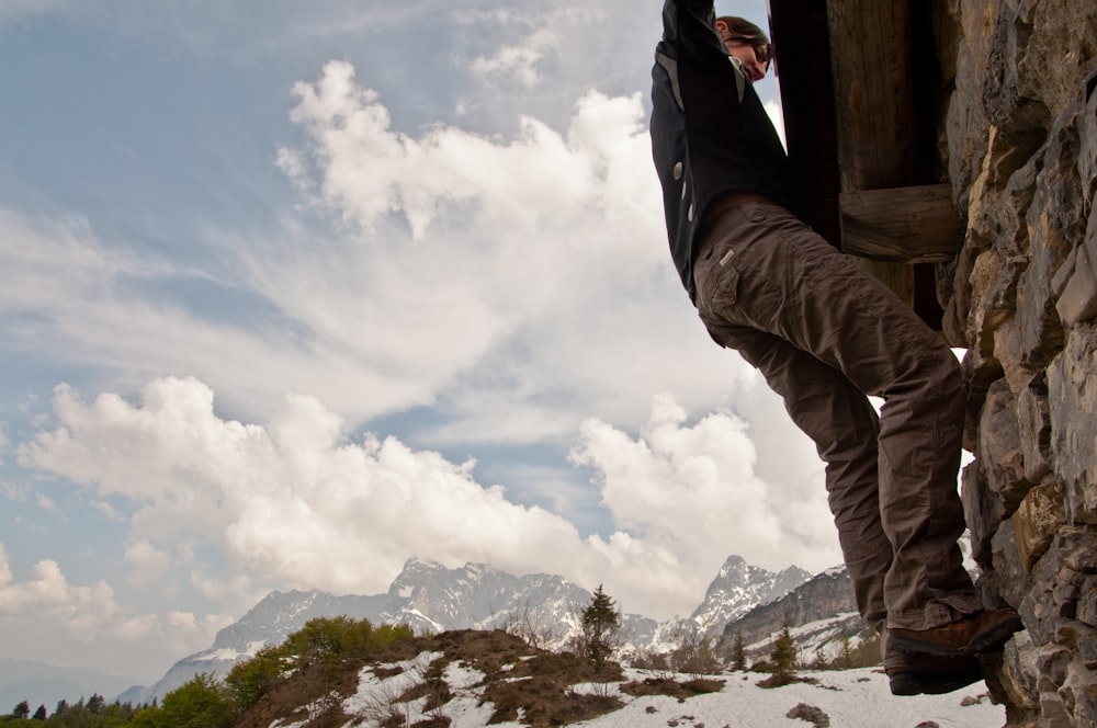 man climbing on wall during daytime