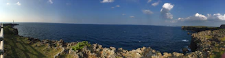 A panoramic view of a famous Brazilian lighthouse standing tall by the ocean on a sunny day.